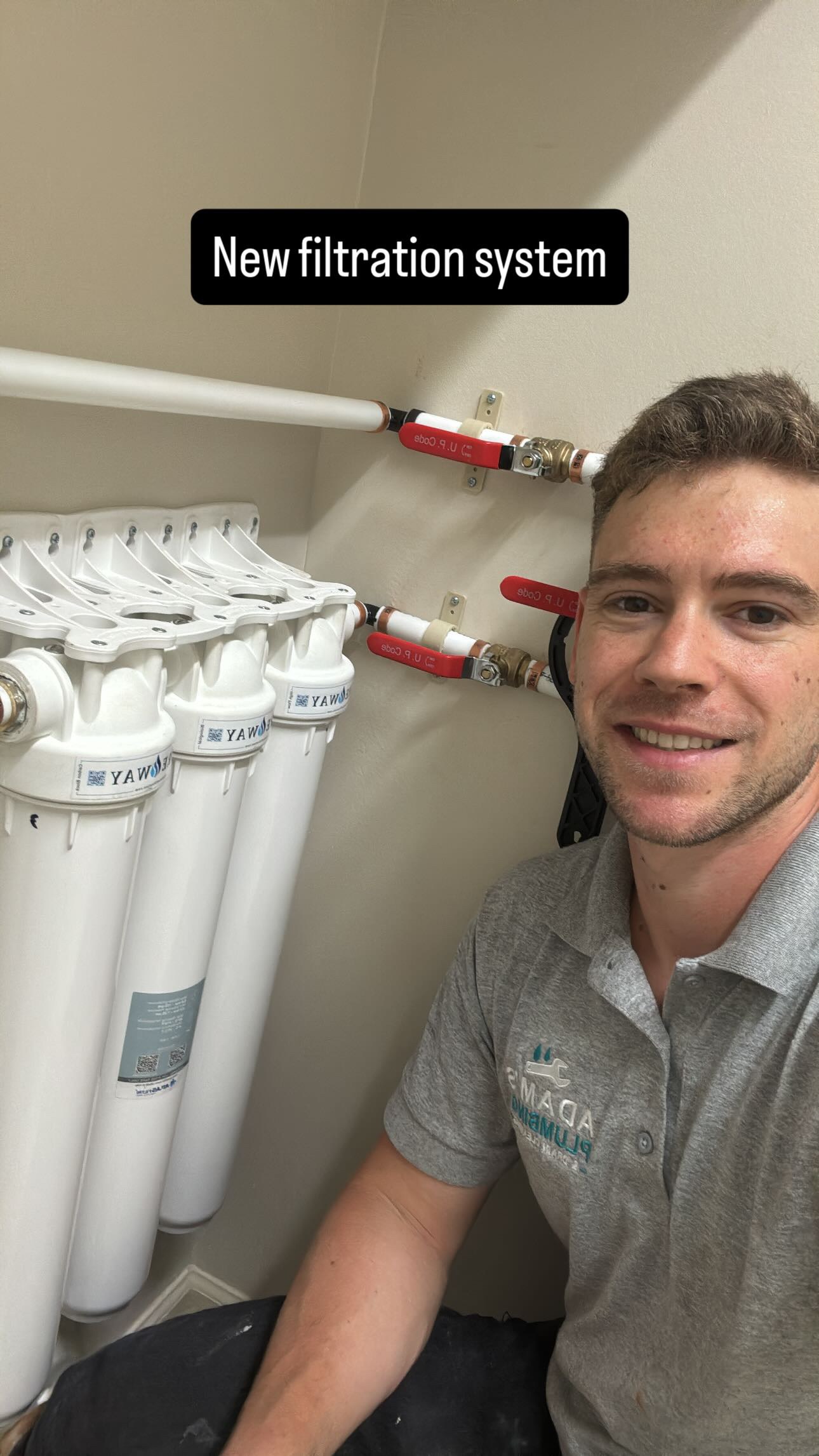 Adam Holder beside a new water filtration system