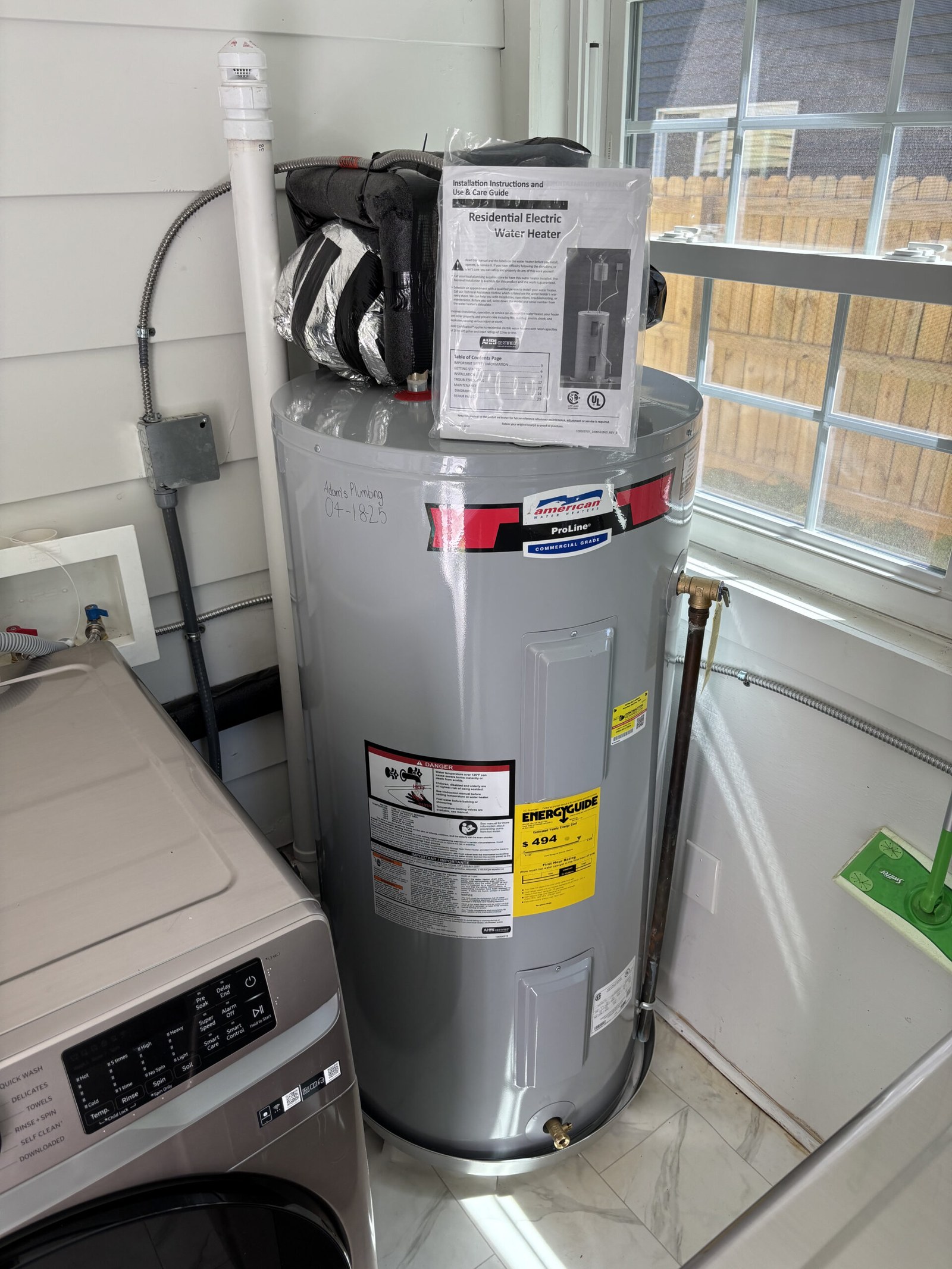 New water heater installed beside a laundry area