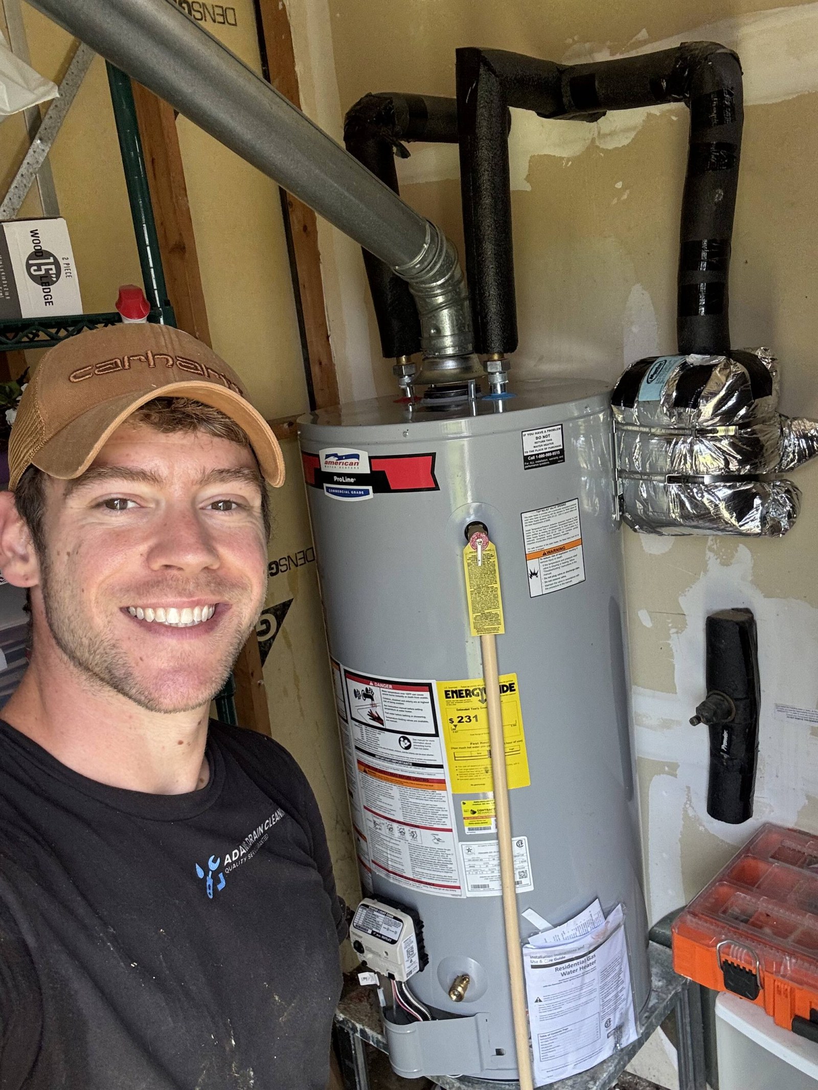 Adam Holder standing beside a newly installed water heater