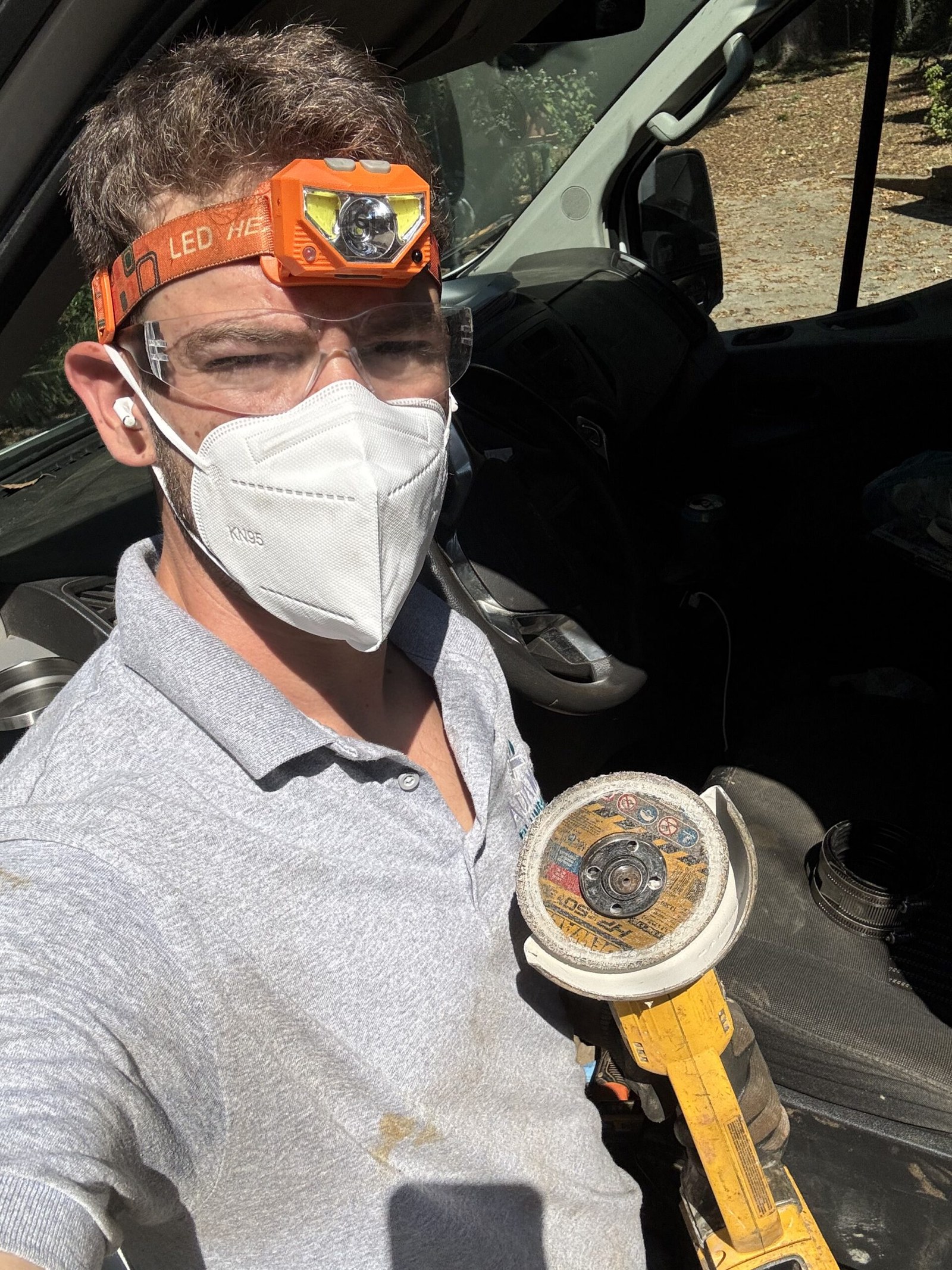 Adam Holder inspecting a job wearing a headlamp and holding a gauge